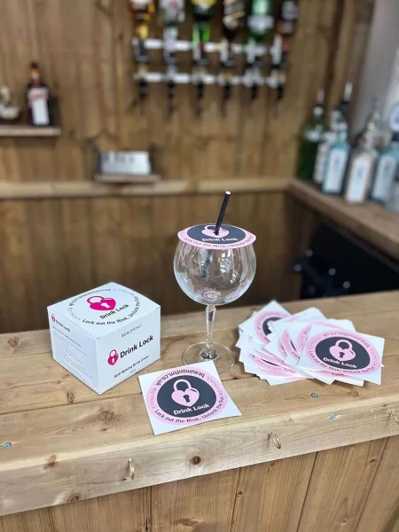 A glass covered with a Drink Lock Anti Spiking Cover